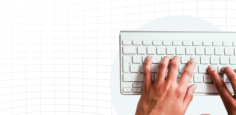 A pair of hands typing away on a white keyboard. 